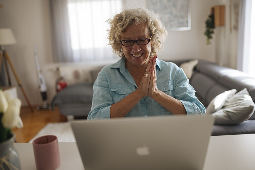 Smiling woman thanking someone on a video call at home